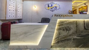 A reception desk with a marble top and a sign that reads "Reception". - Itsy Hotels Signature, Nehru Nagar (Ahmedabad)