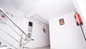 A stairwell with a fire extinguisher mounted on the wall and a "DANGER" sign near the top. - Hotel Lyf Corporate Suites Noida Sec-56 (Noida)