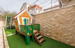 A children's playhouse with a wooden exterior, a blue door, and a green staircase. - Villa Ivan ZadarVillas (Novigrad)