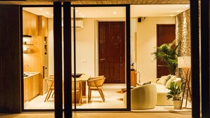 Un intérieur moderne comprenant un coin repas, un canapé et une grande fenêtre.