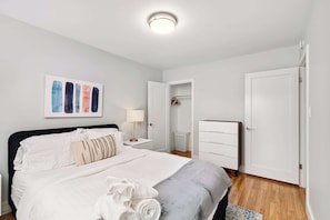 A neatly arranged bedroom with a bed, bedside table, and a wardrobe.