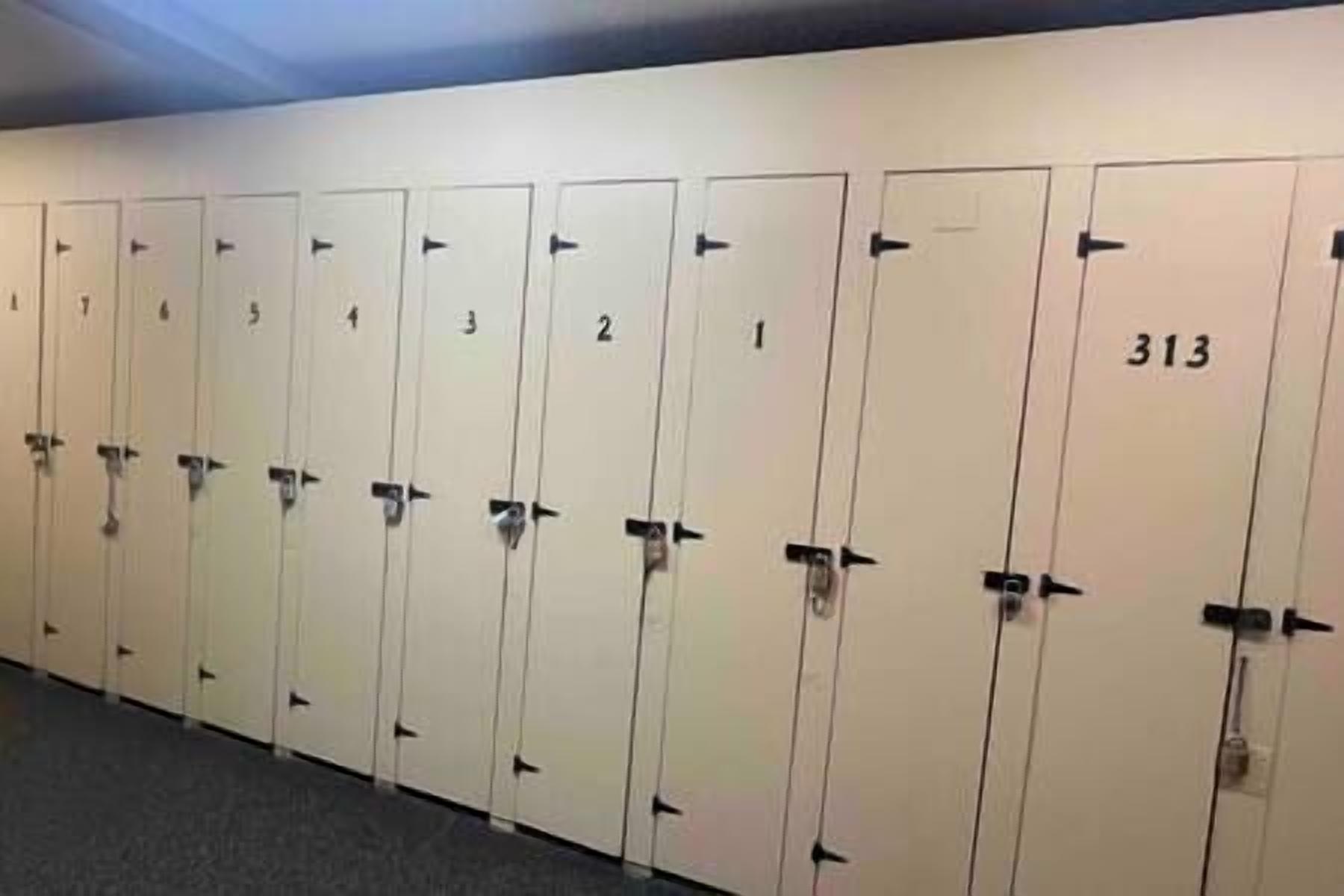 A row of white lockers numbered 1 to 313 in a hallway.