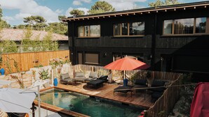 A modern house with a swimming pool, wooden deck, and outdoor seating area. - Kaze Océan The Originals Relais (Lège-Cap-Ferret)