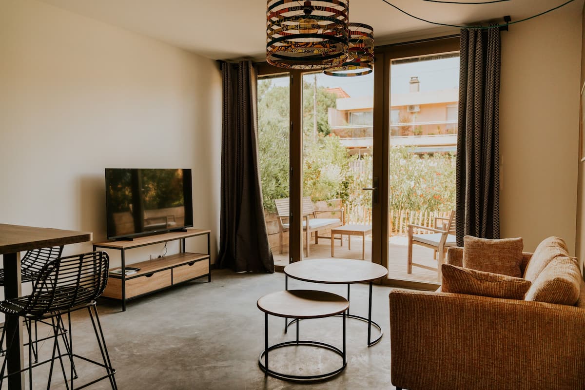 Standard Apartment | Living area | 50-inch Smart TV with cable channels, books