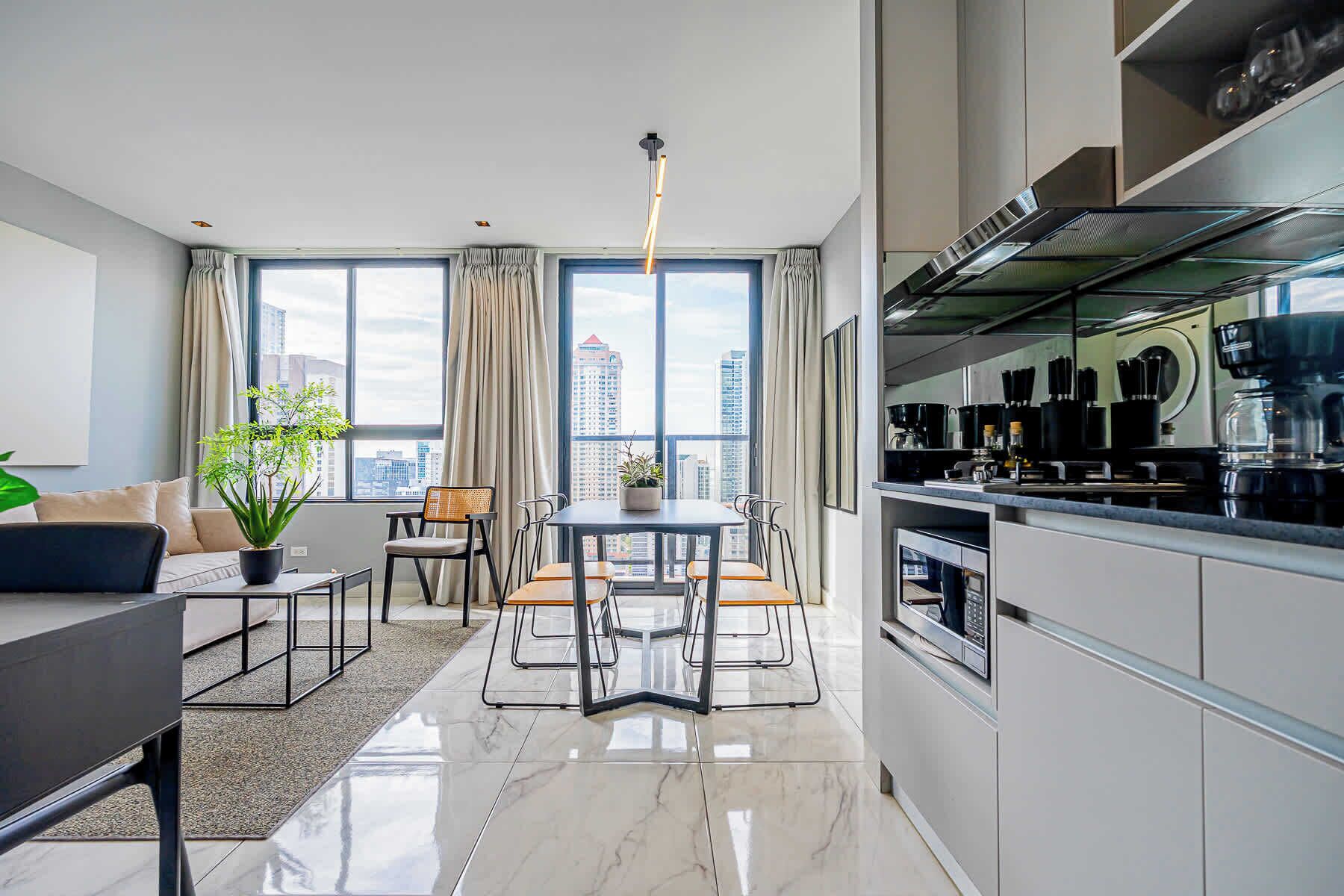 A modern apartment with a dining area, kitchen, and living space.