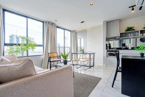 Een moderne woonkamer met een bank, eethoek en keuken.