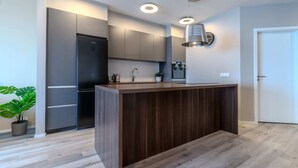 A modern kitchen with a central island, built-in appliances, and a pendant light.