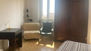 A room with a bed, a desk, a chair, and a wardrobe. - Panoramic two-room apartment on the banks of the Dora River - Da Momo (Torino)