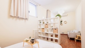 Un dormitorio moderno con cama, mesita de noche y armario blanco.
