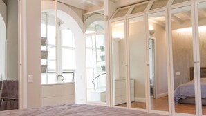 A bedroom with a bed, a wardrobe, and a window.