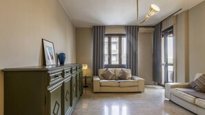 A living room with a beige sofa, a green cabinet, and a floor lamp.