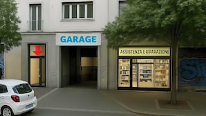 A building with a 'GARAGE' sign and an 'ASSISTENZA E RIPARAZIONE' service.