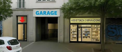 A building with a 'GARAGE' sign and an 'ASSISTENZA E RIPARAZIONE' service.