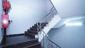A staircase with metal railings and a red fire hose on the left. - Hotel Lyf Corporate Suites - Peera Garhi (New Delhi)