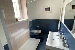 A bathroom with a bathtub, a sink, a toilet, and a shower.
