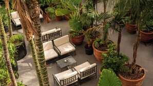 An outdoor patio area with seating, potted plants, and a tiled floor. - Palazzo Talìa - Small Luxury Hotels of the World (Rome)