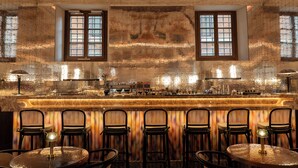 A bar with a marble countertop, multiple stools, and a decorative ceiling. - Palazzo Talìa - Small Luxury Hotels of the World (Rome)