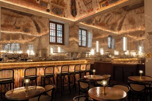 A bar area with multiple seating arrangements and a decorative ceiling.