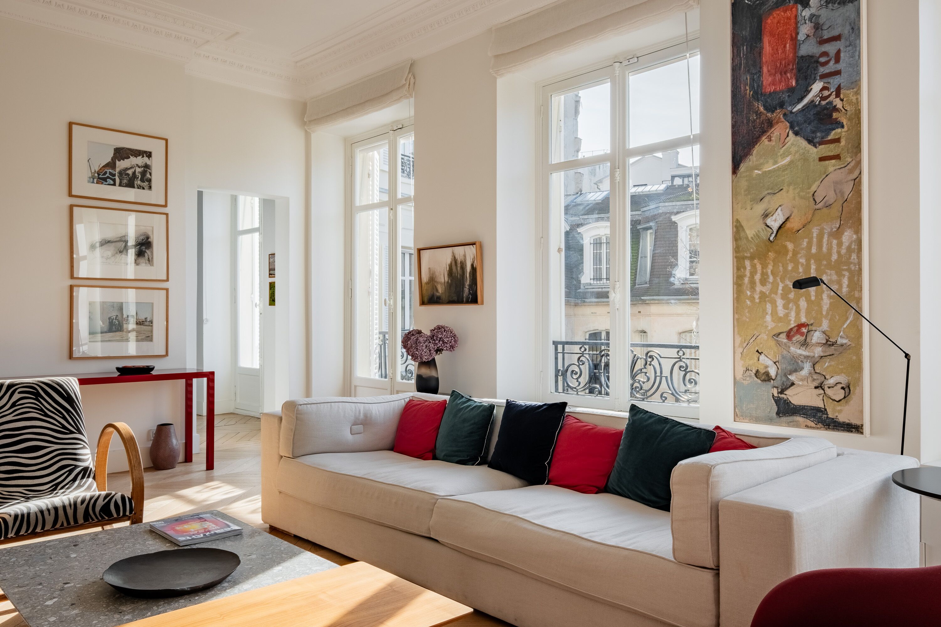 A spacious living room with a large sofa, a zebra-patterned chair, and a wooden coffee table.