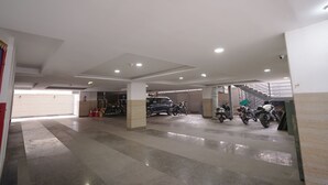 Un aparcamiento de varios niveles con varios coches y motocicletas estacionados.