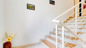 A staircase with white railings and wooden steps, leading to an upper floor.