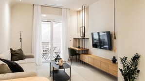 Un salon moderne comprenant un canapé, une table basse, un téléviseur et un coin repas.