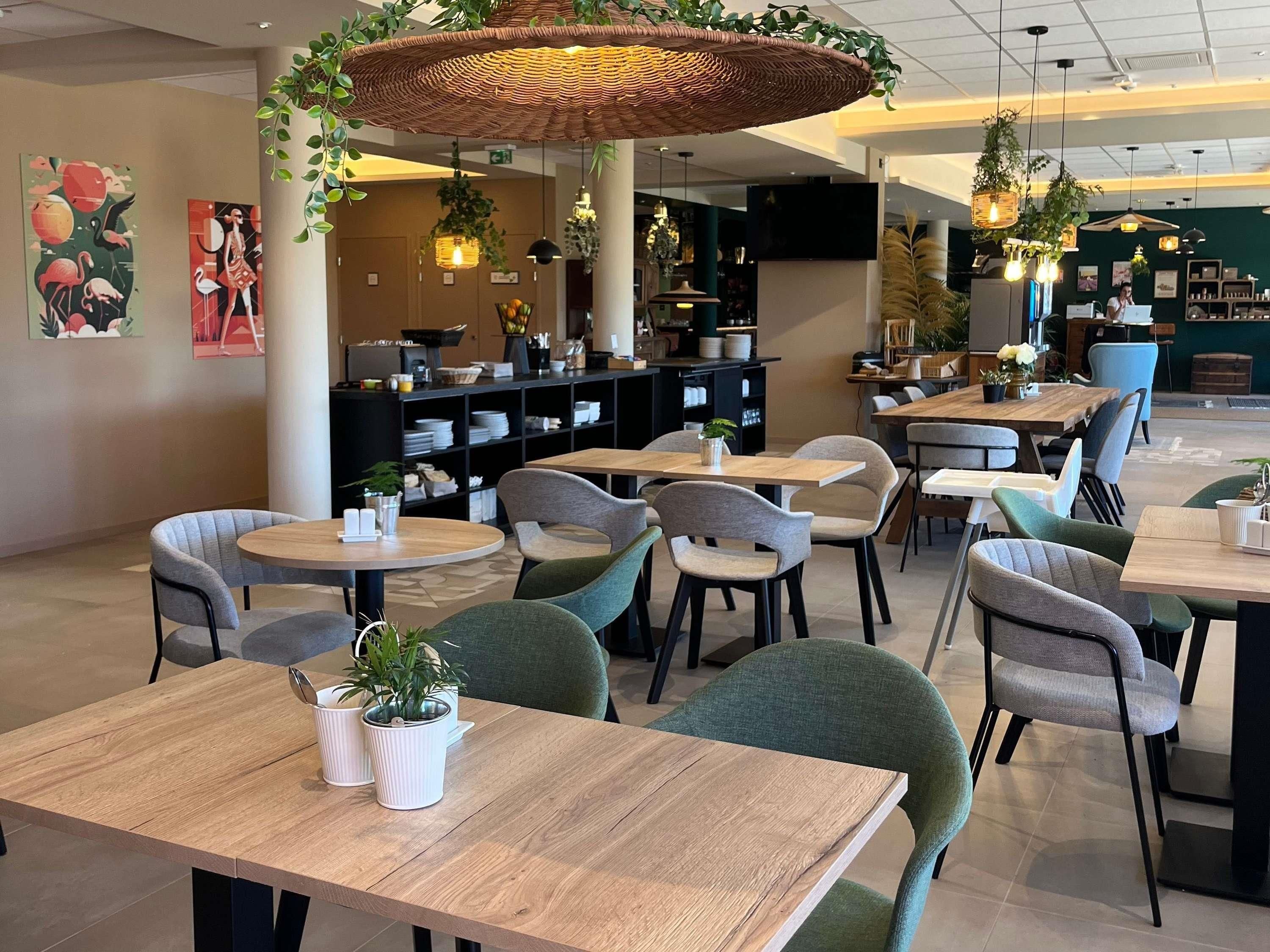 En modern caféinredning med runda bord, bekväma stolar och hängande lampor av rotting.