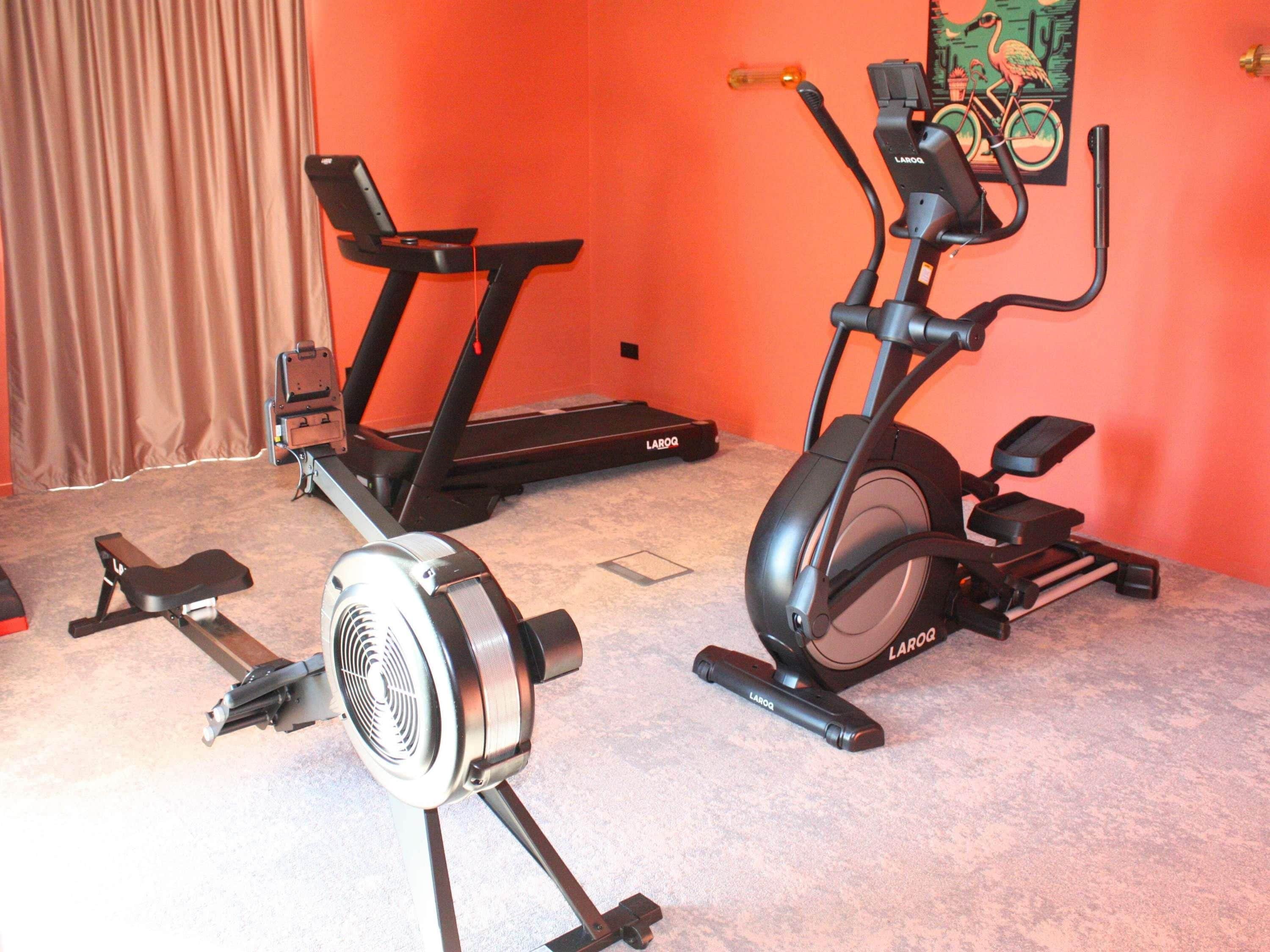 Une salle de sport à domicile équipée de deux vélos d’appartement et d’un ventilateur.
