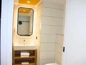 Een douche, handdoeken, zeep, shampoo