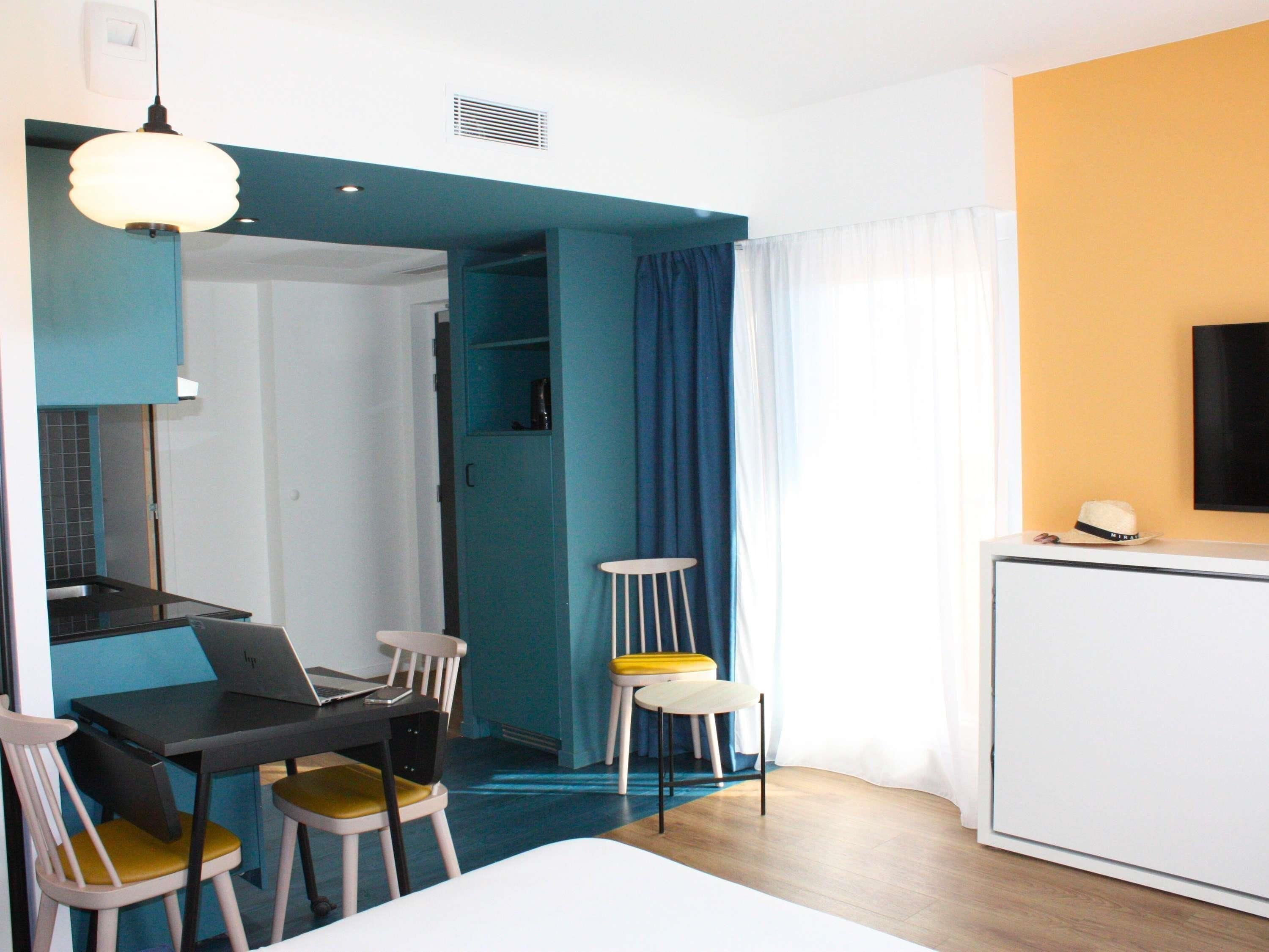 Ein modernes Hotelzimmer mit Essbereich, Fernseher und Bett.
