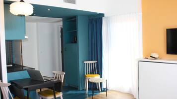 Ein modernes Hotelzimmer mit Essbereich, Fernseher und Bett.