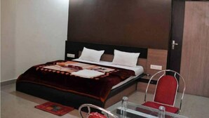 Un dormitorio con cama, mesita de noche, una silla y un armario.