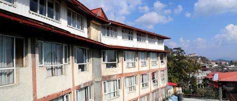 Un edificio de varios pisos con grandes ventanales y techo rojo.