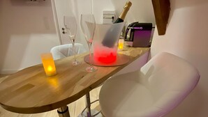 Ein Esstisch mit zwei Weingläsern, einer Kerze und einer Champagnerflasche.