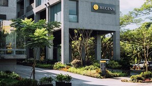 A modern building with a sign reading "BEGINS". It features multiple floors with large windows and a parking area in front. - HOTEL BEGINS (Keelung)