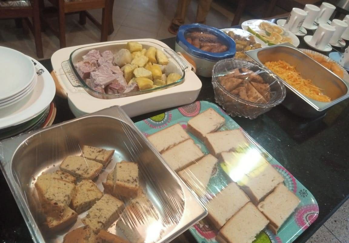 Une table de buffet proposant divers aliments, notamment du pain tranché, des pommes de terre et d’autres plats.