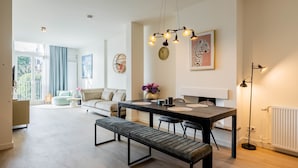 Un salon moderne avec un coin repas, comprenant un banc, une table à manger et une suspension.