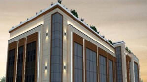 A modern building with large windows, a flat roof, and a paved entrance area. - Hotel Rudra Inn  (Bakshi Ka Talab)