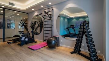 Een moderne sportschool met trainingsapparatuur, een grote spiegel en een neonbord.