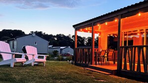 Un espace extérieur abrité, doté d’une terrasse, de chaises et d’une table.