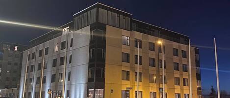Un hotel de varios pisos con un diseño moderno, que presenta una combinación de fachadas de vidrio y ladrillo, y una entrada visible con un letrero.