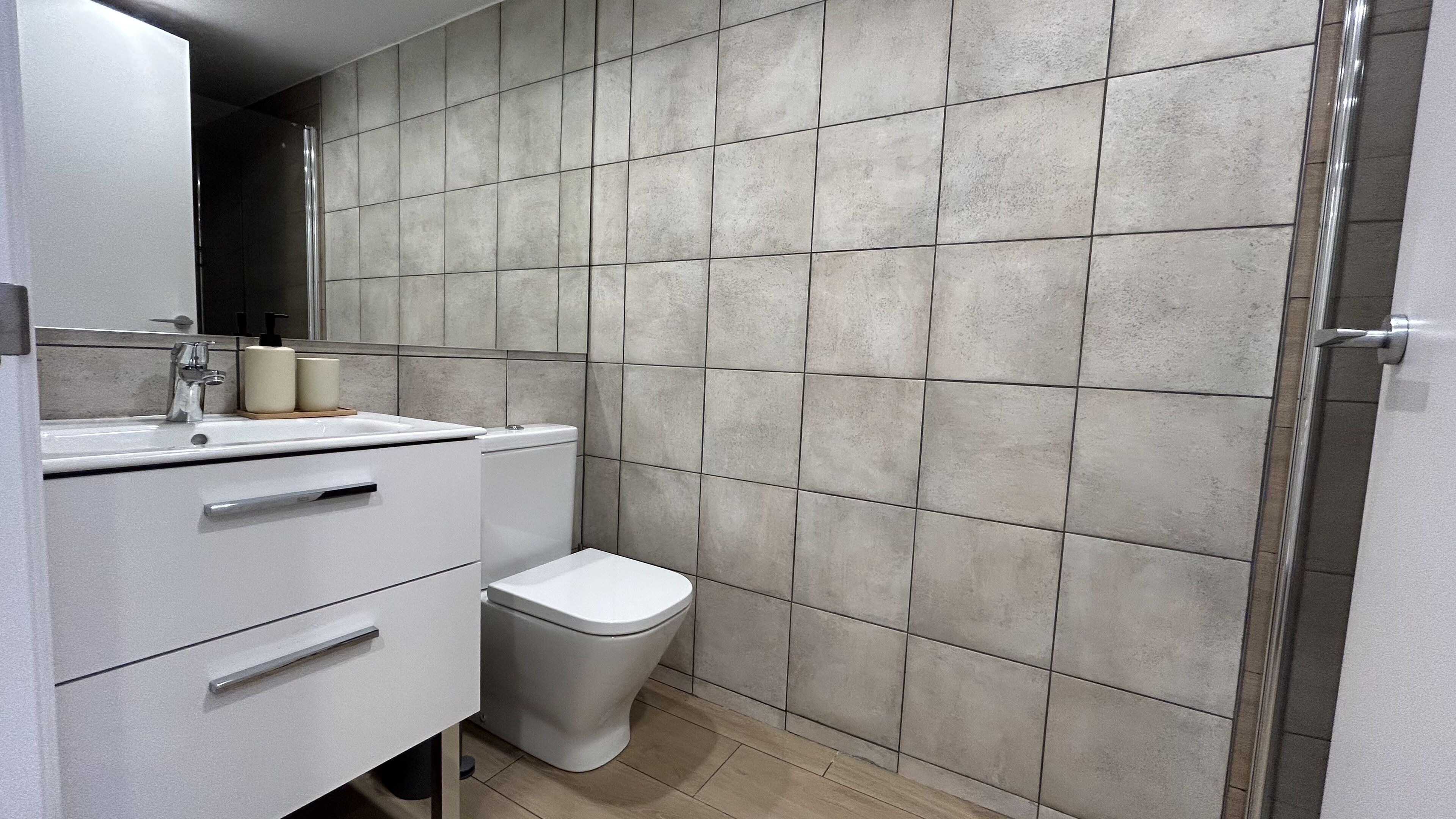 A bathroom with a white sink, a toilet, and a shower area.