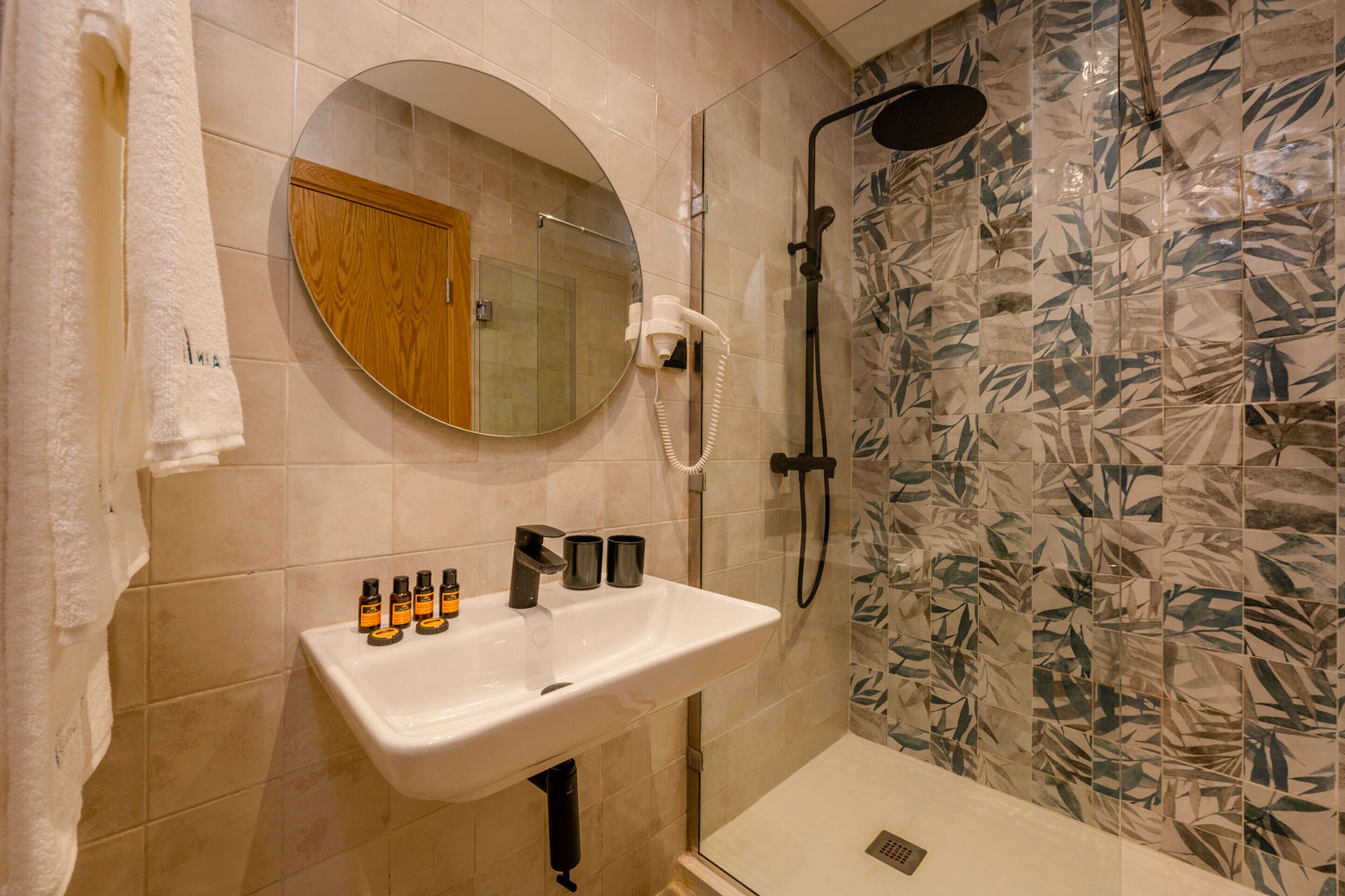 Ein Badezimmer mit Waschbecken, Spiegel und Dusche.