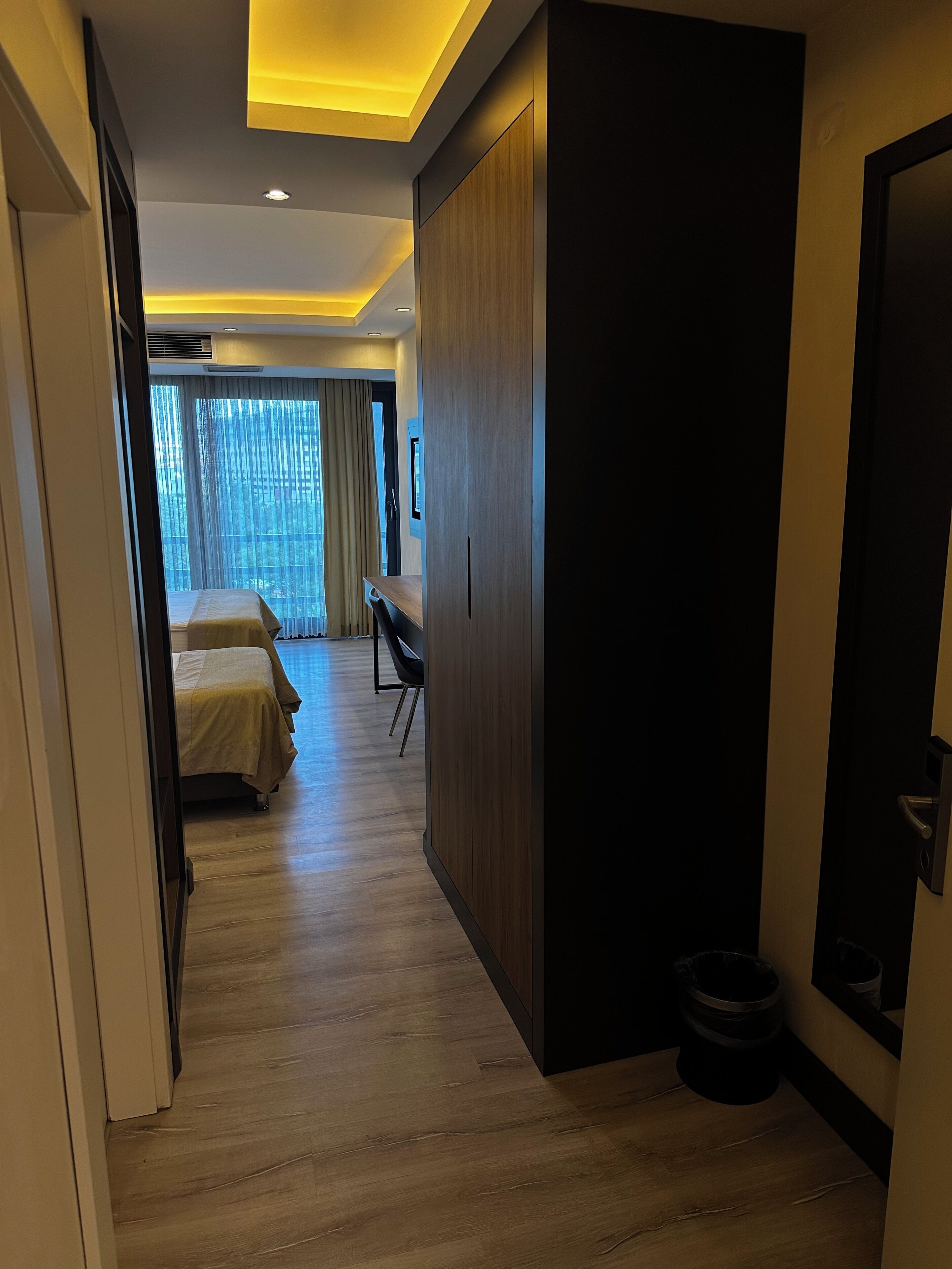 A hotel room with a bed, a desk, and a wardrobe.