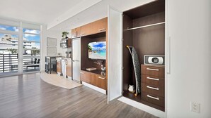 Una cocina moderna con armarios de madera, televisor integrado y armario de puertas correderas.