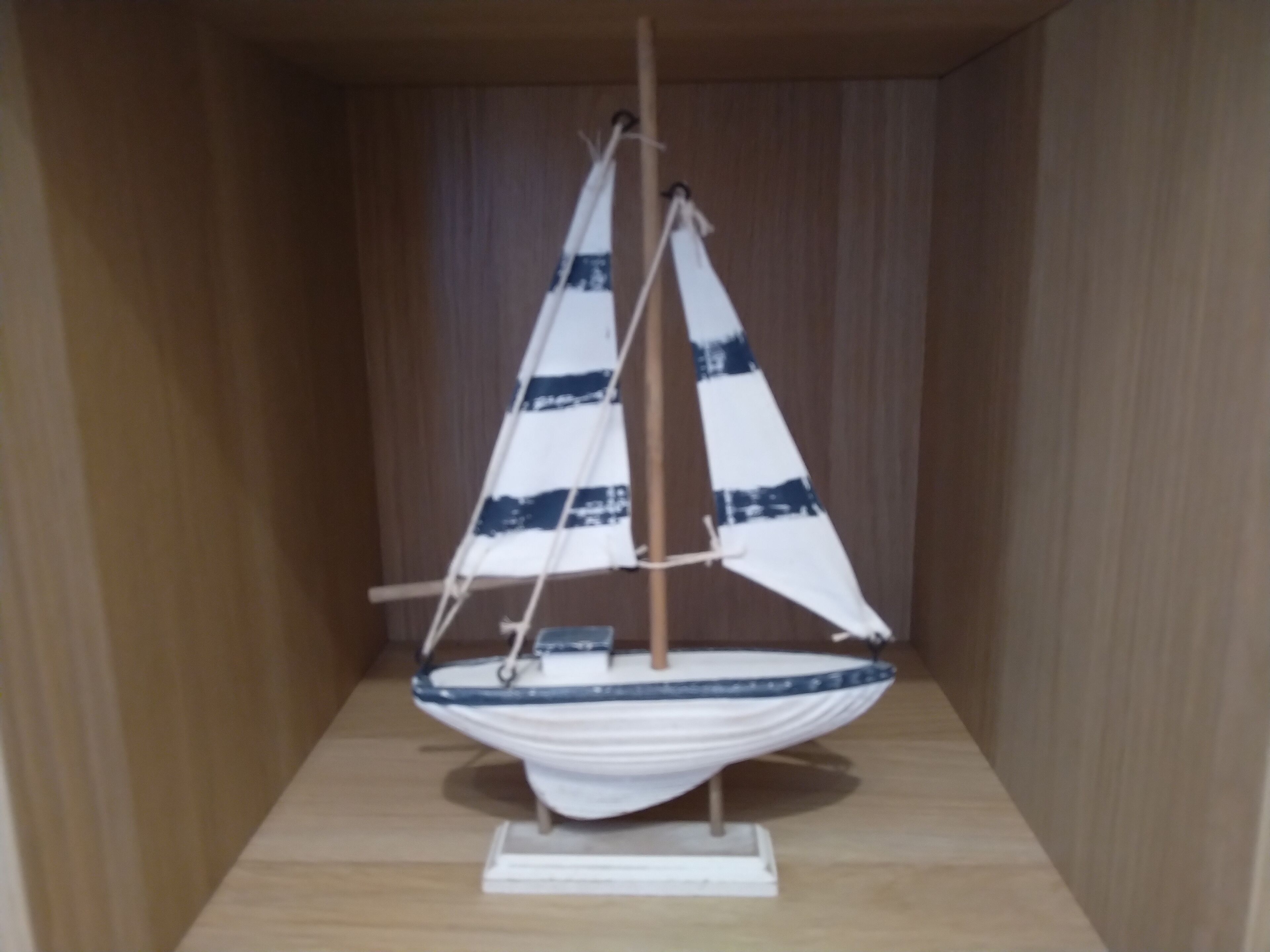 A model sailboat in a wooden display case.
