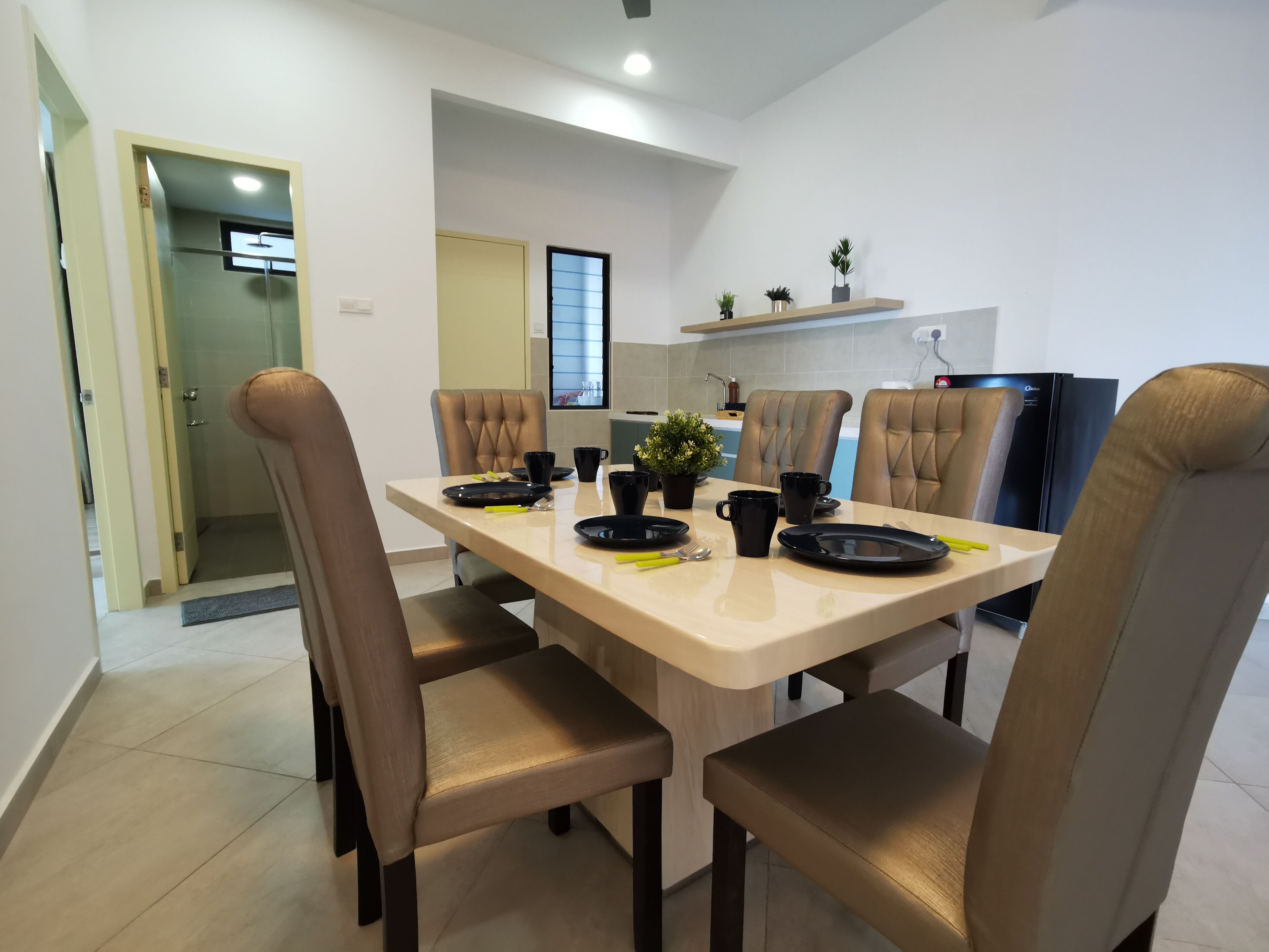 A dining area with a table set for four, surrounded by upholstered chairs.