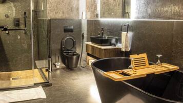 A modern bathroom with a glass-enclosed shower, a freestanding bathtub, a vanity with a sink, and a mirror above the vanity.