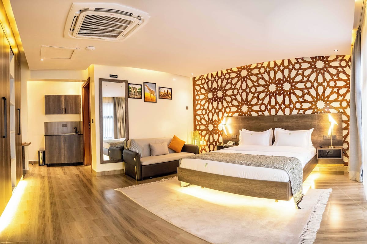 Une chambre d’hôtel moderne équipée d’un grand lit, d’un canapé, d’un bureau et d’une armoire.