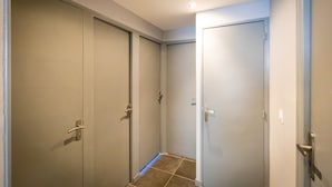 A hallway with two closed doors, a tiled floor, and a ceiling light. - Résidence Hermès Paris Orly Aéroport (Villeneuve-le-Roi)